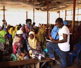 An MSF staff member takes information from new patients at the outpatient therapeutic feeding center in the Jega local government area of Kebbi state.