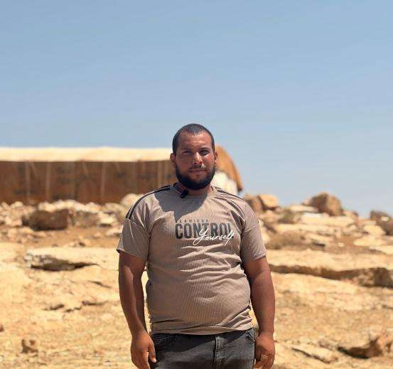A man stands facing the camera in the West Bank, Palestine. 