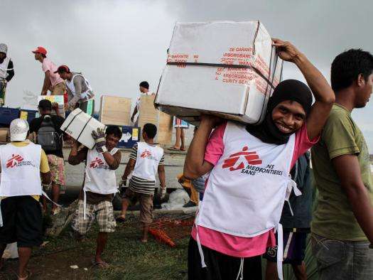 MSF logistician and daily workers unload a truck with humanitarian supplies on the premises of MSF’s tent hospital in Guiuan.