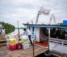 An MSF worker unloads medical supplies off a boat in Brazil. 