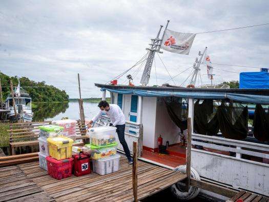 An MSF worker unloads medical supplies off a boat in Brazil. 