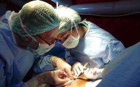 An MSF operating room nurse provides support during a surgery.