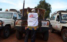 An MSF technical logistician examines the engine of an MSF vehicle.