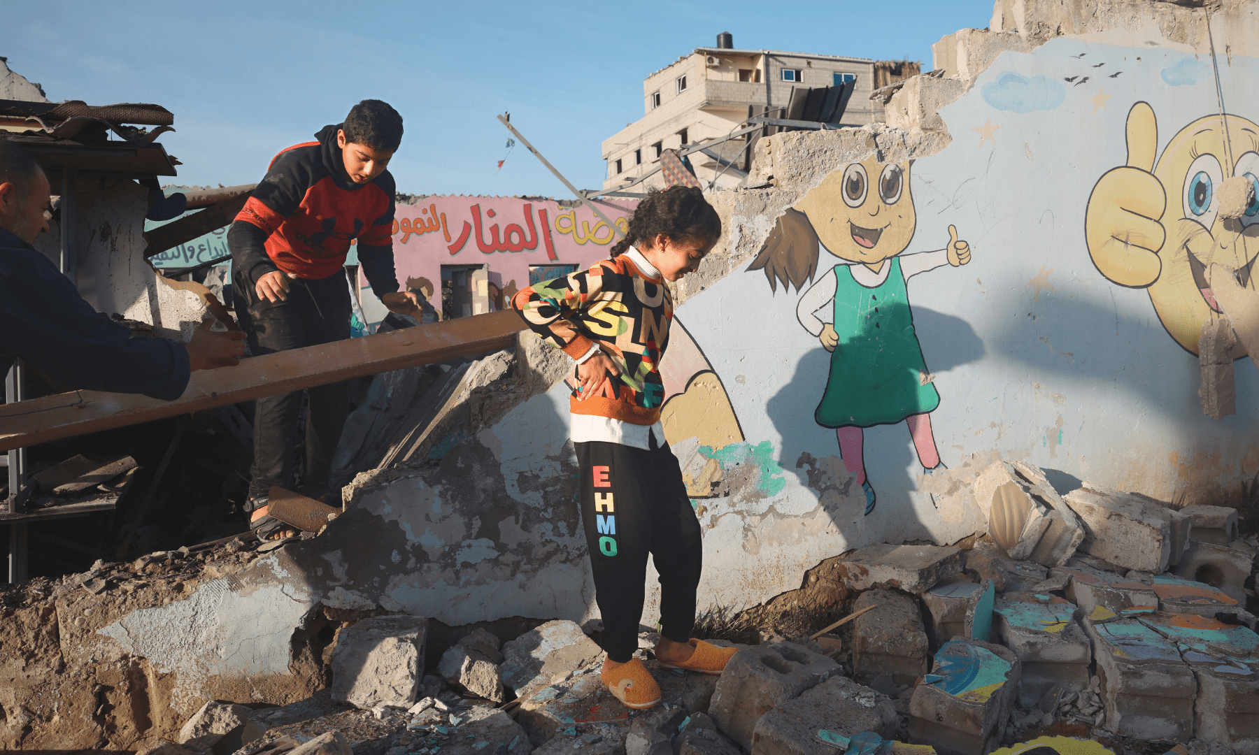 Palestinian children walk through the rubble of a destroyed building in Gaza.