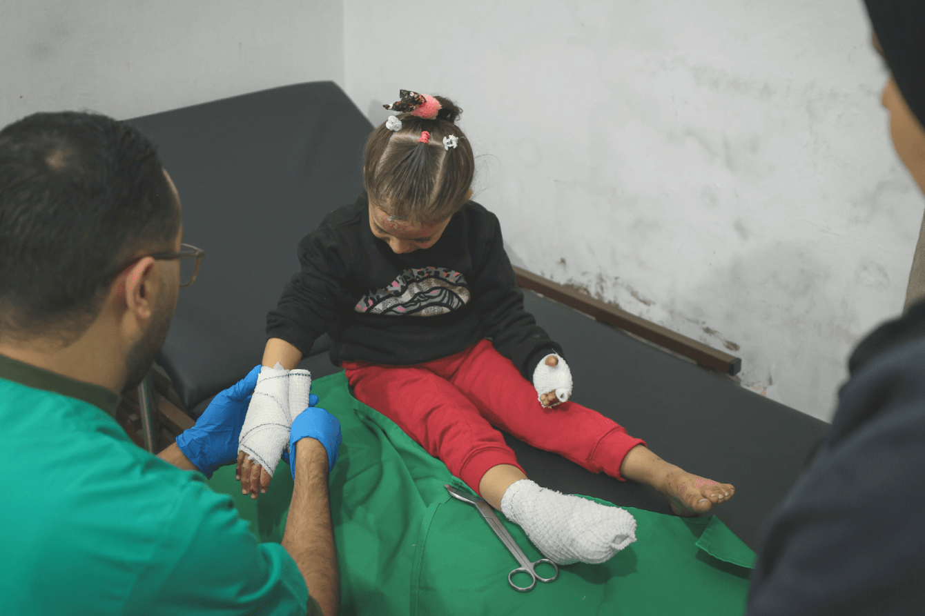 MSF nurse Belal is tending to Sham’s dressings at the clinic in Gaza City. After their house in Beit Hanoun was targeted, she sustained burn injuries.