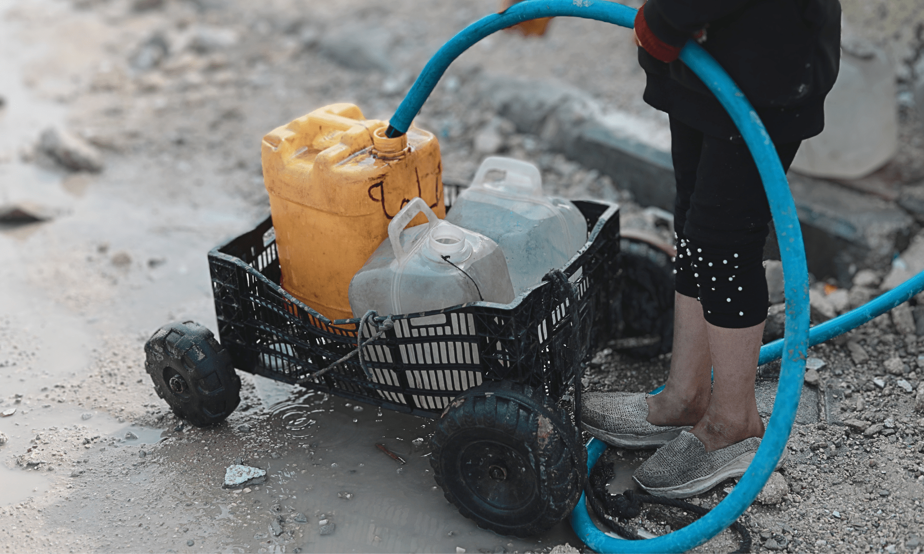 A Palestinian child fills jerrycans with water in Beit Lahia, northern Gaza.