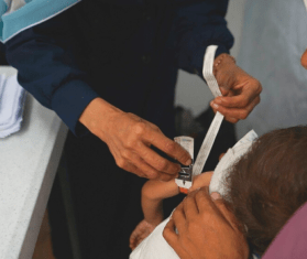 Teams measure a child's arm at MSF's clinic in Gaza City in June 2025. 