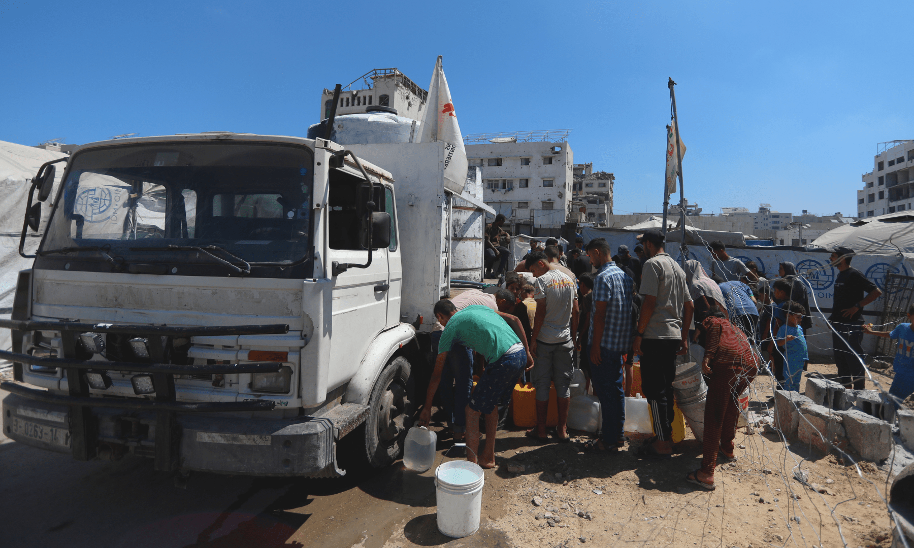 Palestinians queue for water outside an MSF water truck in Gaza.